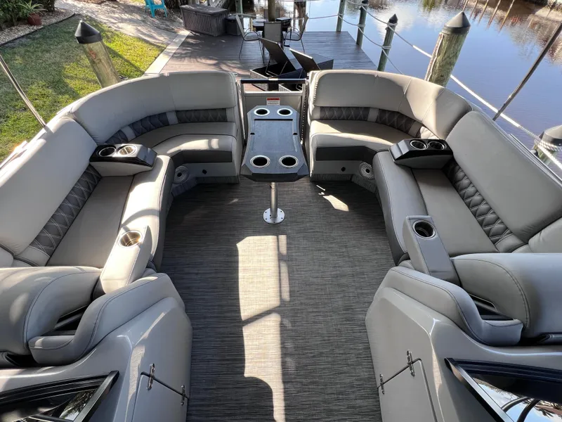 Slide: The Image of Luxurious seating area on 2021 Bennington QX 27 pontoon boat with table and cup holders. - 30