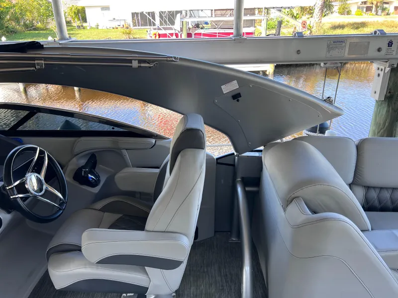 Slide: The Image of 2021 Bennington QX 27 QFB X2 boat interior with luxurious seating and steering wheel. - 38