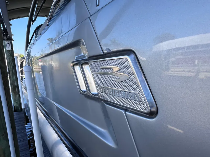 Slide: The Image of 2021 Bennington QX 27 QFB X2 boat, sleek silver exterior with logo detail. - 7