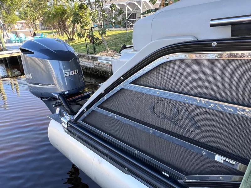 Slide: The Image of 2021 Bennington QX 27 pontoon boat with Yamaha 300hp engine on a calm waterway. - 8