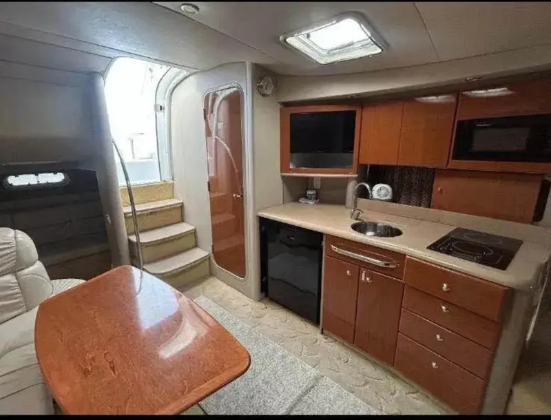 Slide: The Image of 2004 Formula 37 PC yacht interior with kitchenette, wooden cabinetry, and dining area. - 23