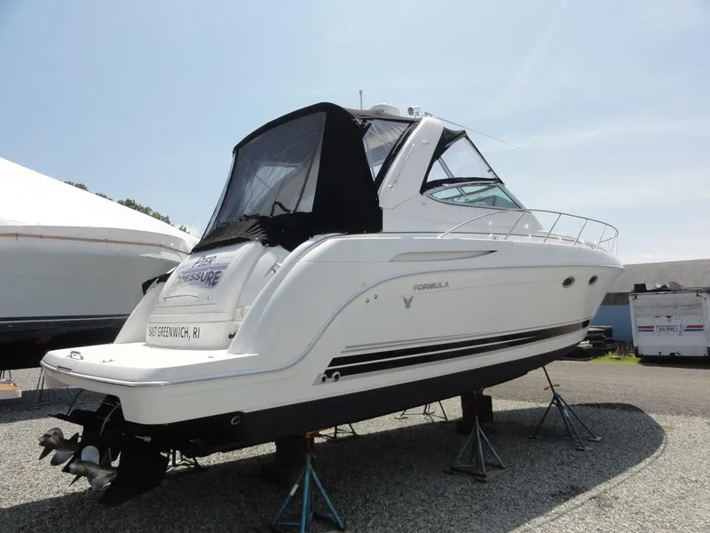 Slide: The Image of 2004 Formula 37 PC yacht on stands, white hull, black canopy, outdoor display. - 3