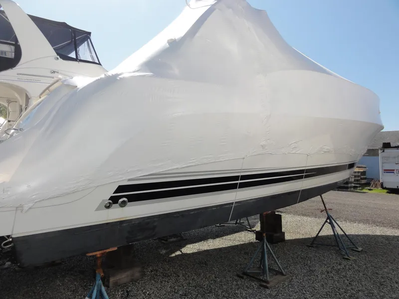 Slide: The Image of 2004 Formula 37 PC boat covered in protective wrap, elevated on stands outdoors. - 46