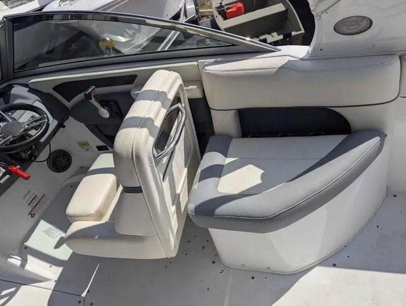Slide: The Image of 2020 Cobalt 25SC boat interior with white and gray seating, steering wheel, and dashboard. - 11