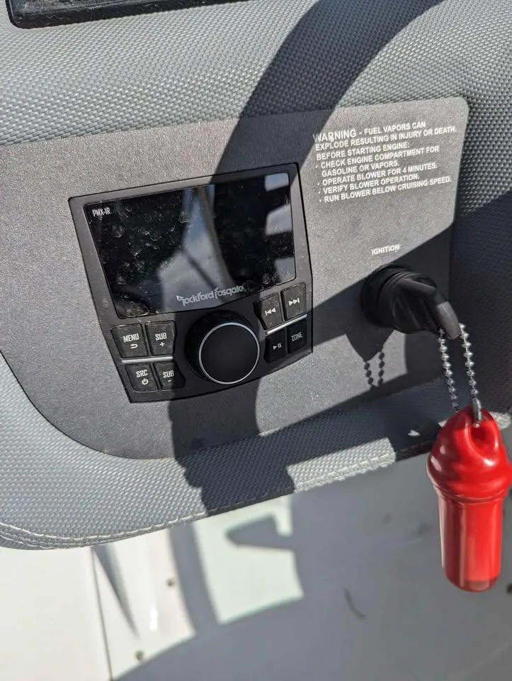 Slide: The Image of 2020 Cobalt 25SC boat dashboard with Rockford Fosgate audio system and safety key. - 14