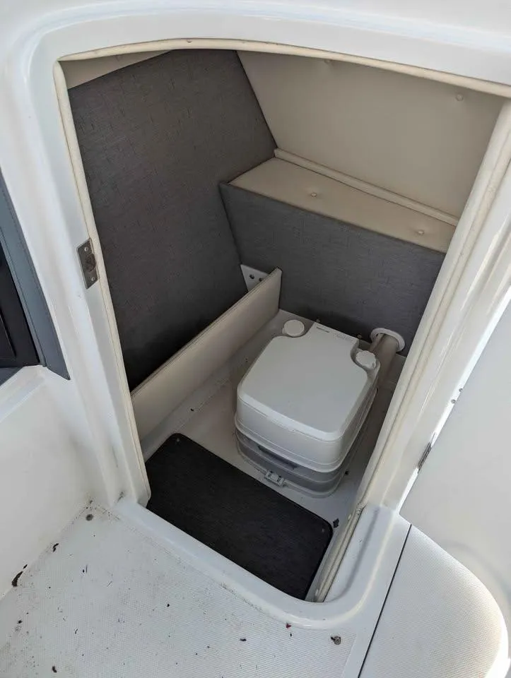 Slide: The Image of 2020 Cobalt 25SC boat interior with compact portable toilet. - 15