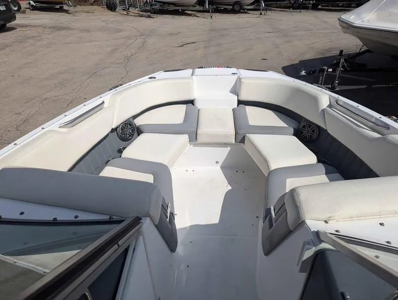 Slide: The Image of 2020 Cobalt 25SC boat interior with white and gray seating, docked outdoors. - 7