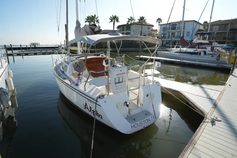 The Image of 1990 Catalina 28 sailboat docked in a marina, sunny day, palm trees in background. - 0
