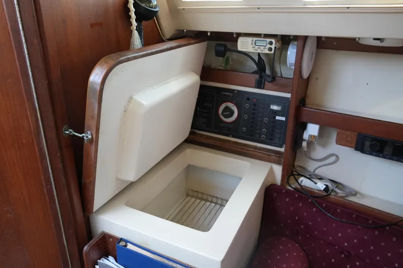 Slide: The Image of Interior of a 1990 Catalina 28 sailboat featuring a storage compartment and control panel. - 15