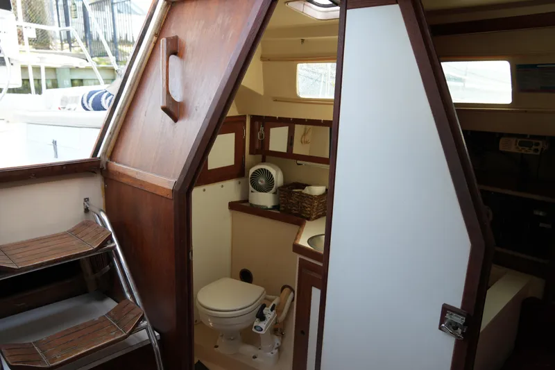 Slide: The Image of Interior of a 1990 Catalina 28 sailboat showing compact bathroom and wooden finishes. - 17