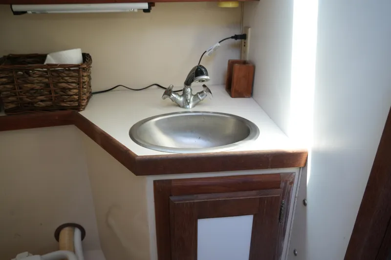 Slide: The Image of 1990 Catalina 28 boat interior with sink and wooden cabinetry. - 18