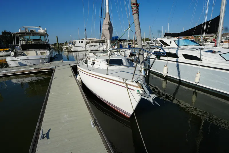 Slide: The Image of 1990 Catalina 28 sailboat docked in a marina under clear blue skies. - 2