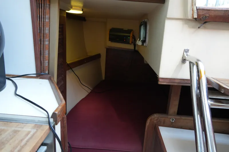 Slide: The Image of Interior cabin of a 1990 Catalina 28 sailboat with maroon cushions. - 20