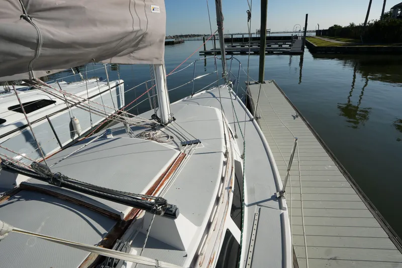 Slide: The Image of 1990 Catalina 28 sailboat docked at marina, calm water, clear sky. - 4