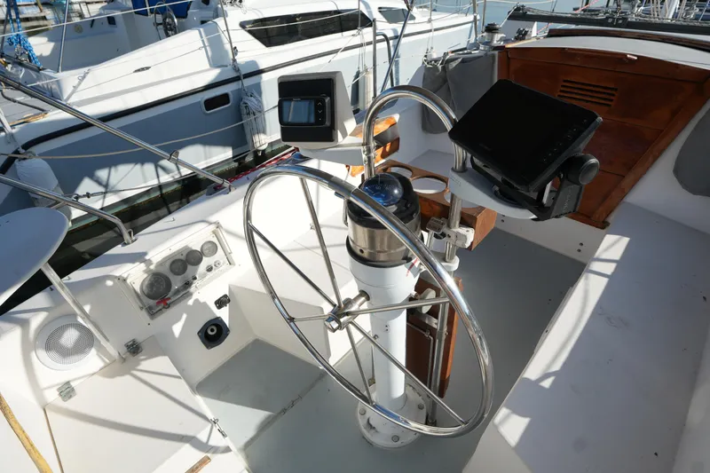 Slide: The Image of Cockpit of a 1990 Catalina 28 sailboat with steering wheel and navigation equipment. - 6