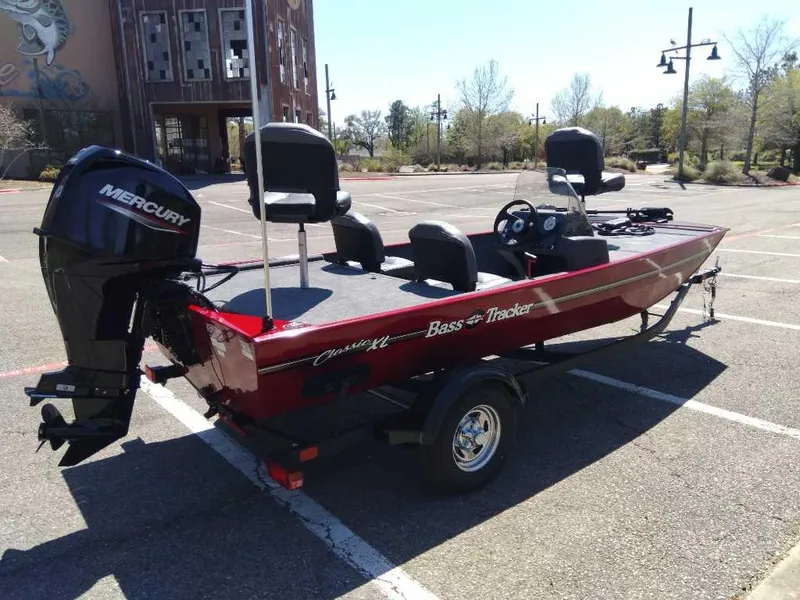 Slide: The Image of 2025 Tracker Bass Tracker Classic XL boat with Mercury engine in a parking lot. - 3