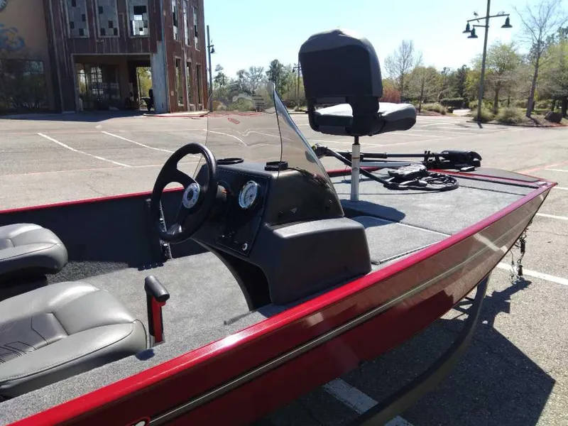 Slide: The Image of 2025 Tracker Bass Tracker Classic XL boat with red trim in a parking lot. - 4