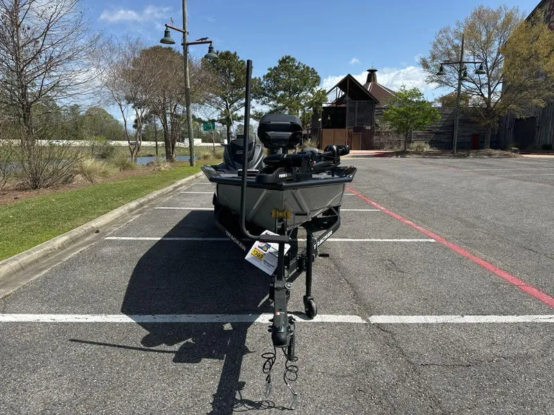 Slide: The Image of 2025 Tracker Pro Team 190 boat parked in a lot, surrounded by trees and buildings. - 3