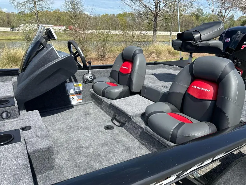 Slide: The Image of 2025 Tracker Pro Team 190 boat interior with gray and red seating, steering console, and carpeted floor. - 5