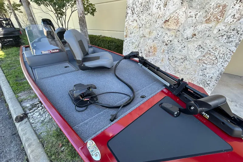 Slide: The Image of 2025 Tracker Bass Tracker Classic XL boat with seating and trolling motor, parked outdoors. - 4