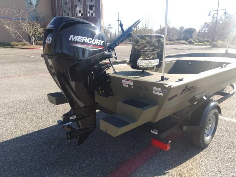 Slide: The Image of 2025 Tracker Grizzly 1654 T Sportsman boat with Mercury outboard motor in a parking lot. - 3