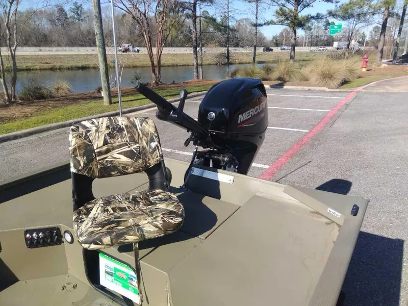 Slide: The Image of 2025 Tracker Grizzly 1654 T Sportsman boat with camo seat and Mercury outboard motor. - 9