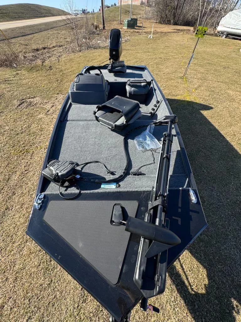 Slide: The Image of 2025 Tracker Bass Tracker Classic XL boat on grassy terrain, featuring fishing equipment. - 6