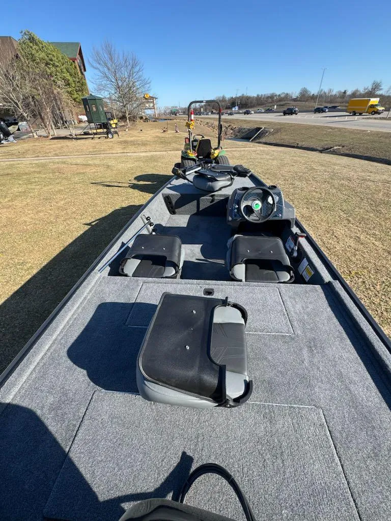 Slide: The Image of 2025 Tracker Bass Tracker Classic XL boat on grassy area, showcasing interior seating and controls. - 7