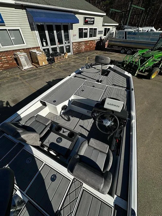 Slide: The Image of 2025 Avid 18 Vertex boat with Garmin system, parked outside a dealership. - 2