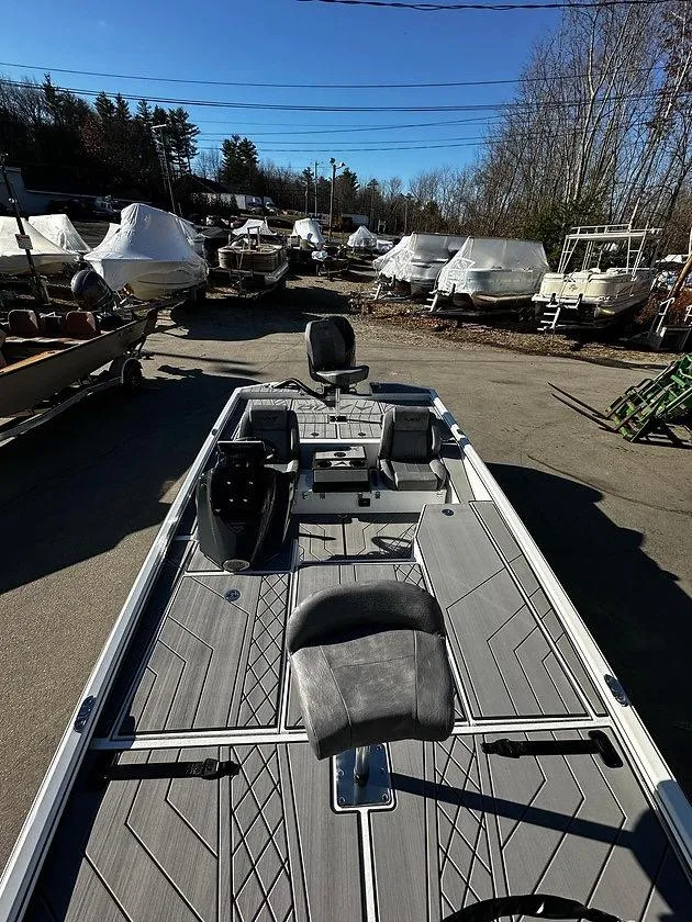 Slide: The Image of Avid 18 Vertex 2025 boat with sleek deck design, parked outdoors. - 4