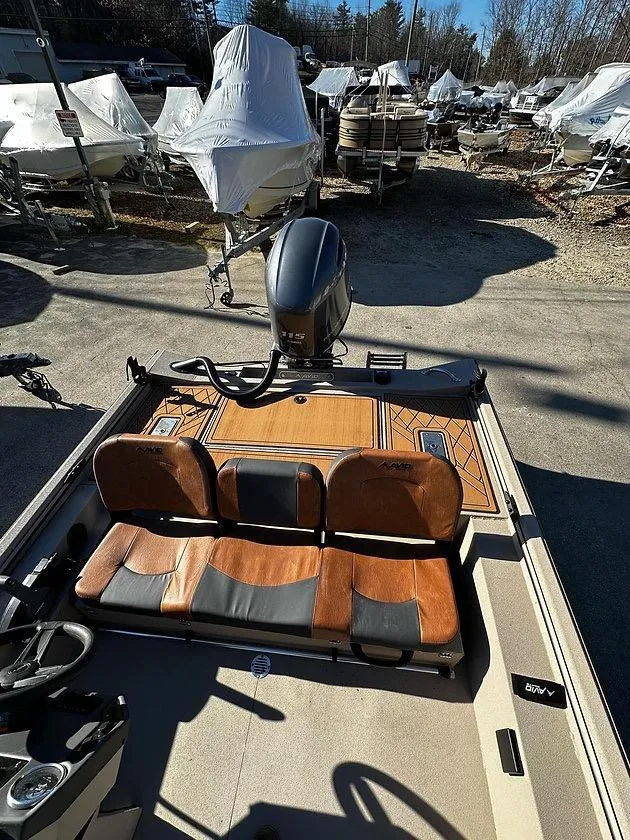 Slide: The Image of 2025 Avid 18 Rogue SC boat with wooden seats, parked among covered boats. - 2