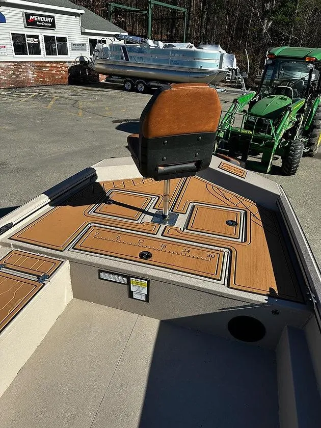 Slide: The Image of 2025 Avid 18 Rogue SC boat with tan deck and swivel seat in a dealership lot. - 3