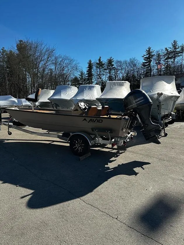 Slide: The Image of 2025 Avid 18 Rogue SC boat on trailer, parked outdoors under clear blue sky. - 6