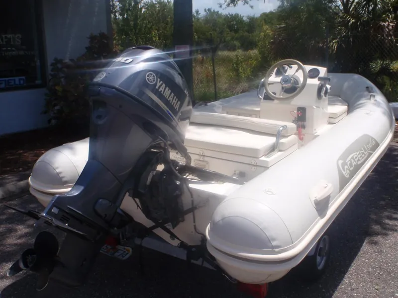 Slide: The Image of 2016 Capelli Tempest 340 LE Tender with Yamaha outboard motor, parked outdoors. - 2