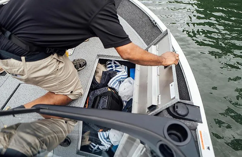 Slide: The Image of Man accessing storage on 2025 Lowe FM 1775 WT boat by the water. - 1