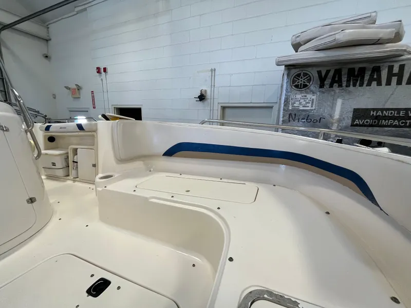 Slide: The Image of Interior of a 2005 Godfrey FD211 boat with Yamaha equipment, featuring white seating and blue accents. - 11