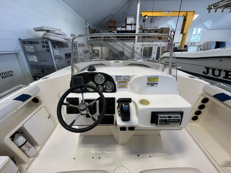 Slide: The Image of 2005 Godfrey FD211 boat dashboard with steering wheel and control panel in a showroom. - 14