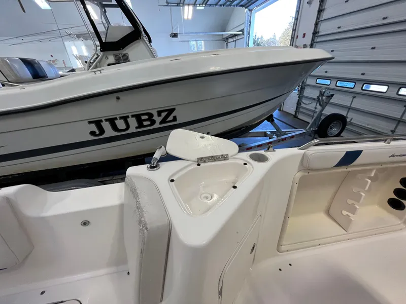 Slide: The Image of Boat interior with sink, Godfrey FD211, 2005 model, in a garage with another boat labeled "JUBZ". - 25