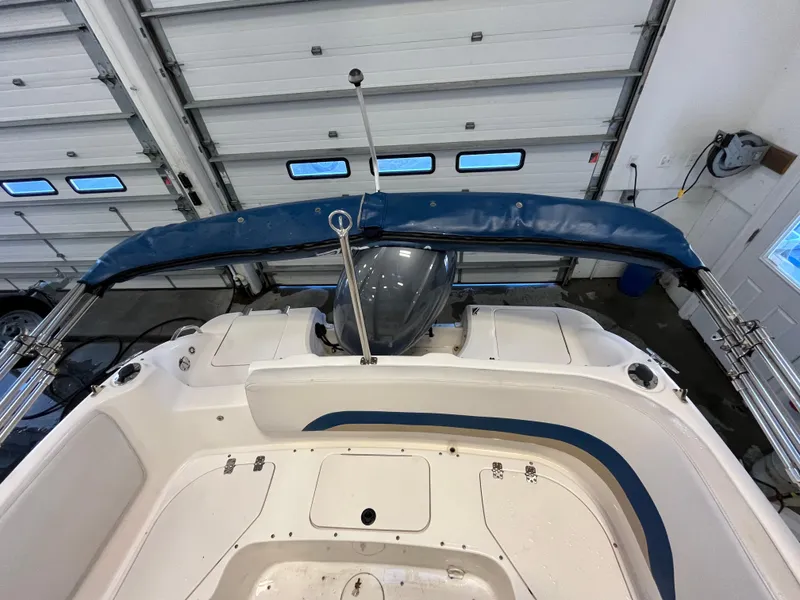 Slide: The Image of 2005 Godfrey FD211 boat interior with blue canopy in a garage setting. - 35