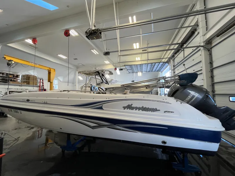 Slide: The Image of 2005 Godfrey FD211 boat in a garage, elevated on a lift for maintenance. - 8