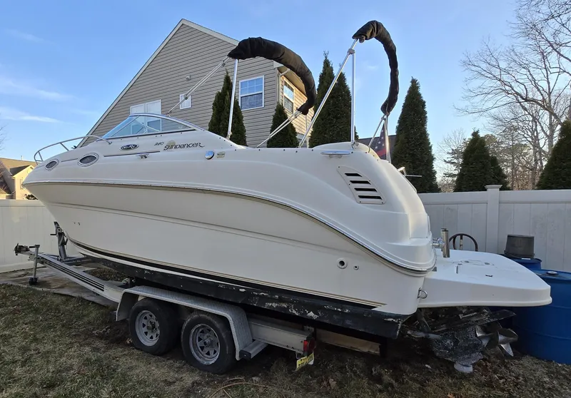 The Image of 2001 Sea Ray 240 Sundancer boat on trailer, parked in residential yard. - 0