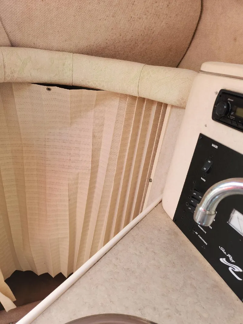 Slide: The Image of 2001 Sea Ray 240 Sundancer cabin interior with control panel and pleated curtain. - 10