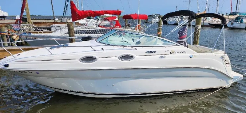 Slide: The Image of 2001 Sea Ray 240 Sundancer boat docked in marina, featuring sleek white design. - 2