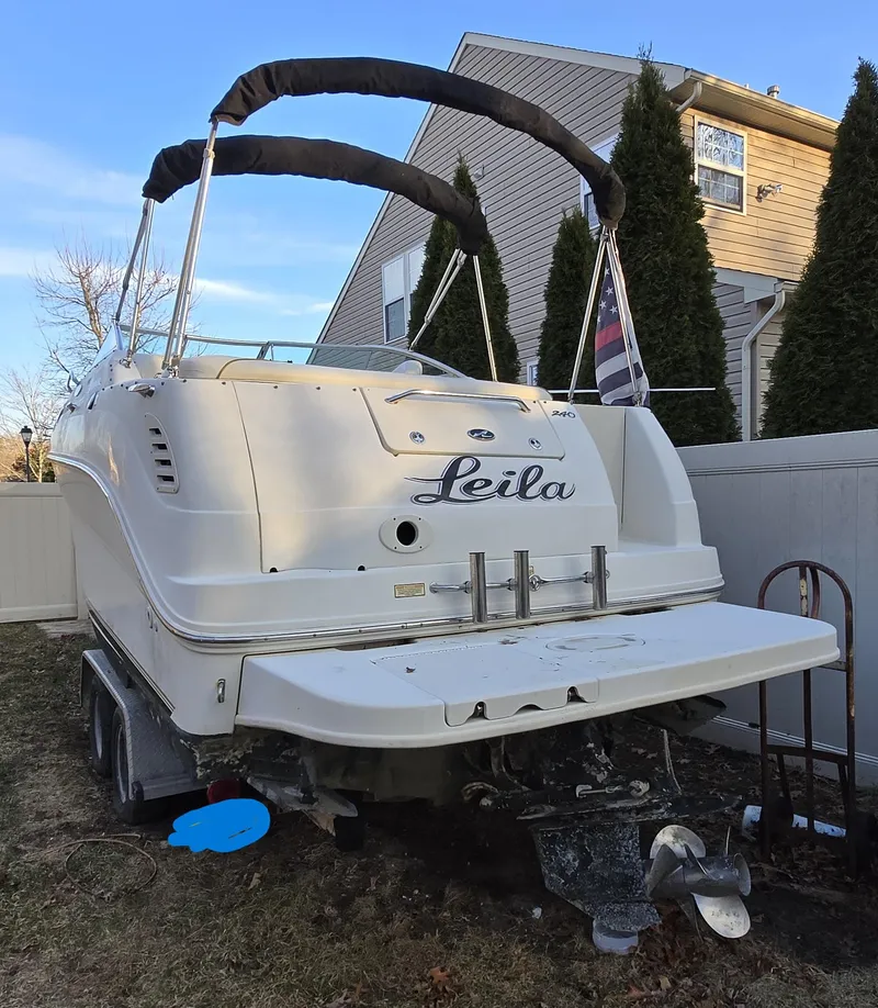 Slide: The Image of 2001 Sea Ray 240 Sundancer boat parked in residential yard, rear view. - 3