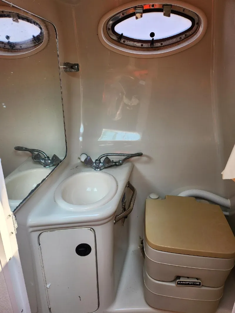 Slide: The Image of 2001 Sea Ray 240 Sundancer bathroom with sink, mirror, and portable toilet. - 8