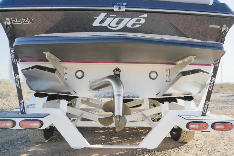 Slide: The Image of 2020 Tigé 25ZX boat rear view on trailer, showcasing propeller and exhaust system. - 6
