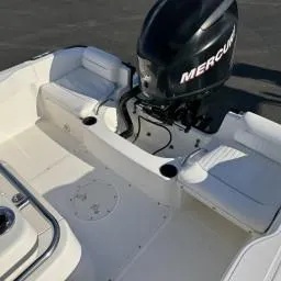 Slide: The Image of 2007 Boston Whaler 190 Outrage boat interior with Mercury engine, featuring white seating. - 9