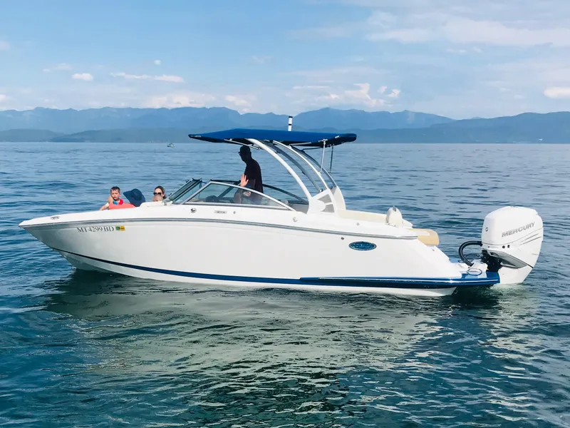 Slide: The Image of 2019 Cobalt 25SC boat cruising on a calm lake with passengers onboard. - 6