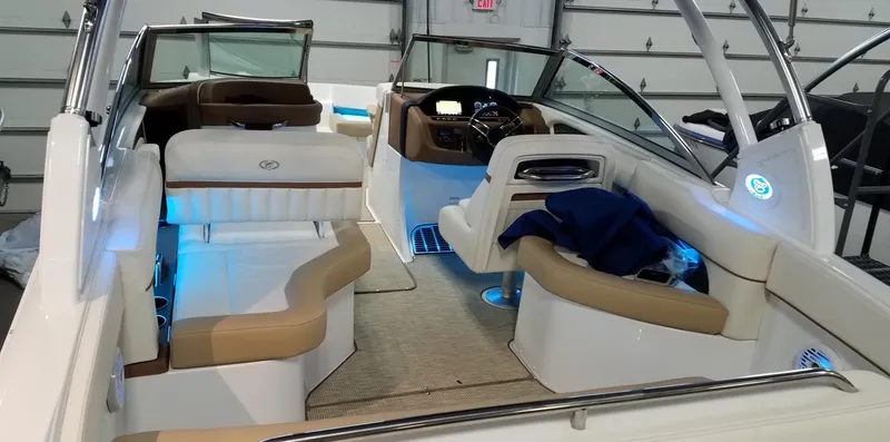 Slide: The Image of 2019 Cobalt 25SC boat interior with beige seating and blue ambient lighting. - 8