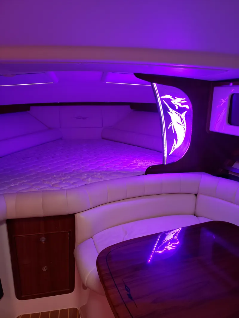 Slide: The Image of 2007 Grady-White Express 360 cabin with purple ambient lighting and elegant seating area. - 13
